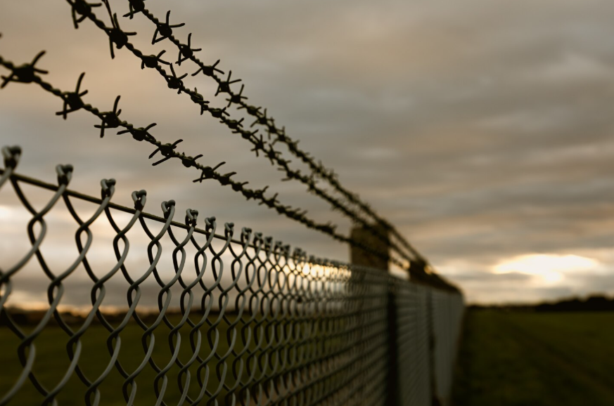 why border disputes happen illustrated by barbed wire fence marking contested boundary